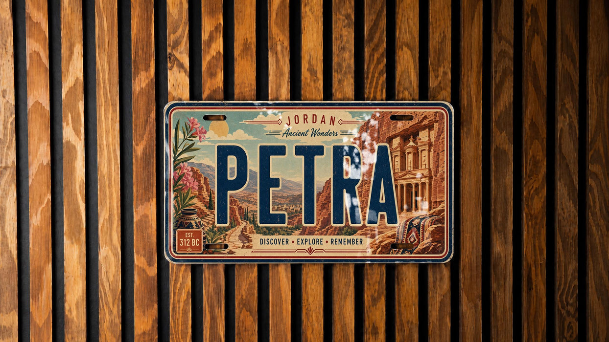 A vintage license plate with the word "PETRA" on it, displayed against a wooden background.
