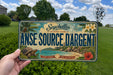 A vintage license plate from Seychelles, La Digue Island, with a tropical island landscape and palm trees.