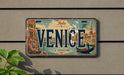 A vintage license plate from Italy that says "VENICE" and features an illustration of Venice, a gondola, and the city's iconic landmarks.