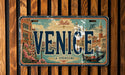 A vintage license plate from Venice, Italy, featuring an illustration of the city's landmarks and a gondola.