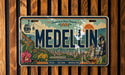 a vintage license plate with a colorful illustration of a cityscape and a horse, along with the text "MEDELLIN" prominently displayed.