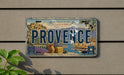 a vintage license plate from Provence, France, with a scenic illustration of the region.