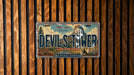 A license plate with the text "Devils Tower" and a scenic illustration of the mountain range.