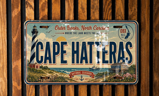 A vintage license plate from Cape Hatteras, North Carolina, featuring a lighthouse and coastal scenery.