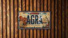 a vintage license plate from the city of Tax, India, with a design that includes the Taj Mahal and other iconic landmarks.