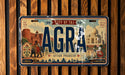 The image is a vintage license plate from India that features the name "AGRA" prominently in the center, with the city of Agra, India, and the state of Uttar Pradesh, India, displayed below. The plate also includes the text "THE TAI MANAL" and "DISCOVER HERITAGE" along the bottom edge.