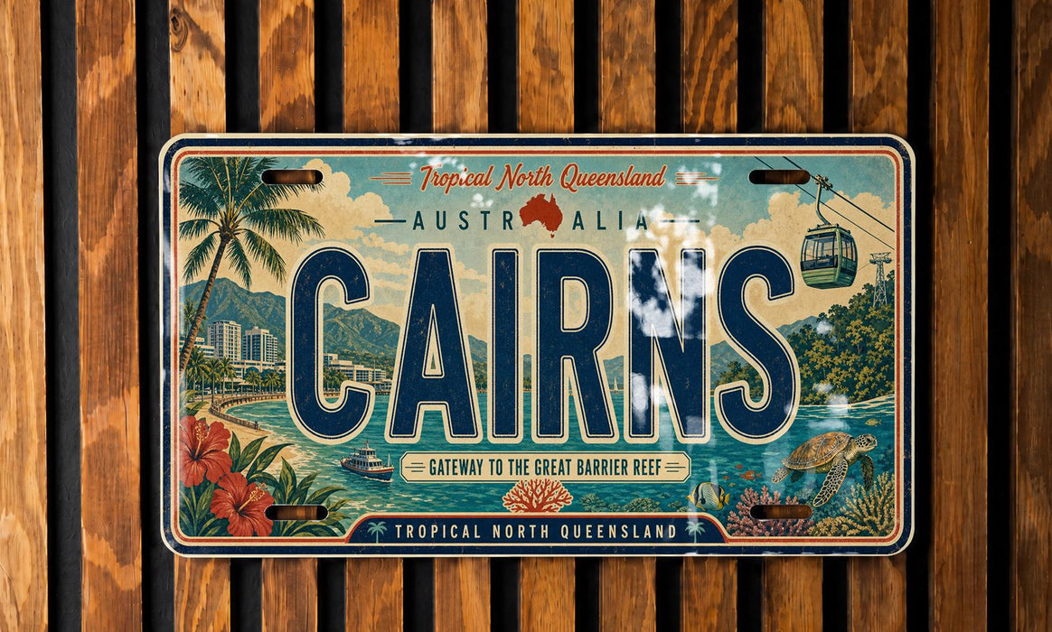 A vintage license plate from Australia, featuring an illustration of a tropical island and water with palm trees, a cable car, and a beach scene.