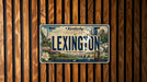 A decorative license plate from Kentucky, featuring illustrations of horses, buildings, and other Kentucky-themed elements.