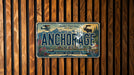 A vintage license plate from Alaska hanging on a wooden wall.