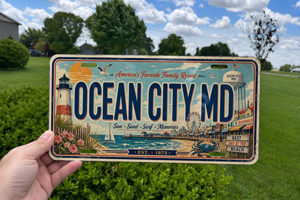 A person is holding a license plate with a beach scene and a lighthouse, against a backdrop of trees and a blue sky.