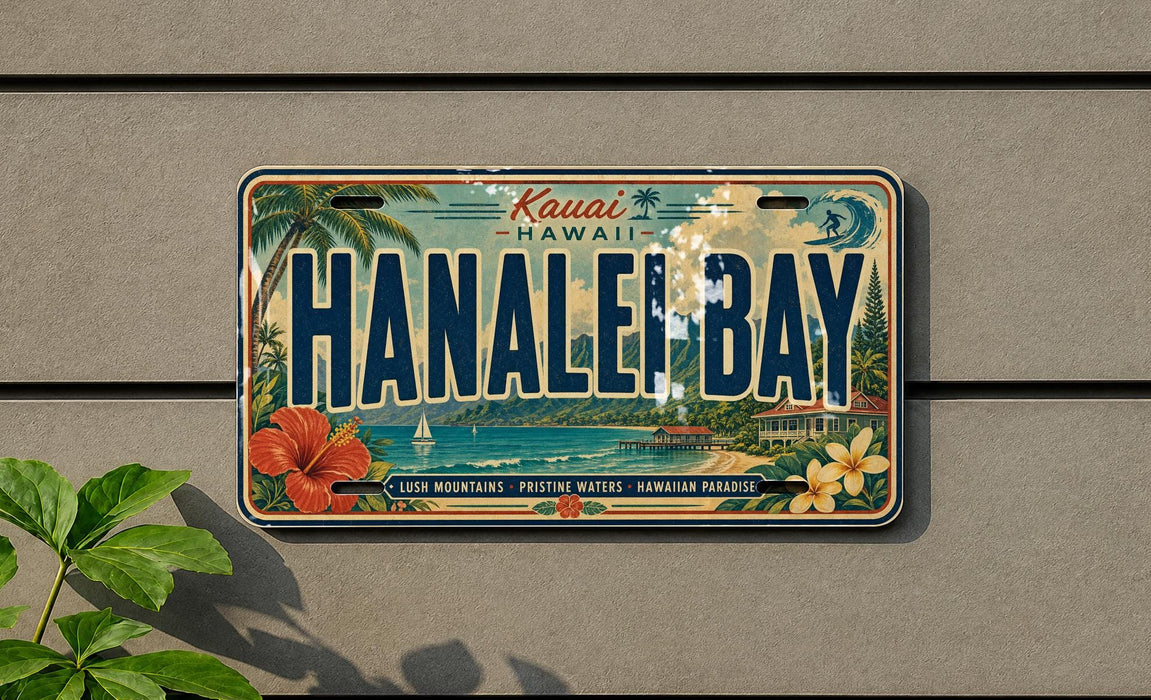 A vintage license plate from Hawaii, featuring the text "Kauai Hanahe Bay" and surrounded by tropical imagery such as palm trees, flowers, and a beach.