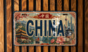 A vintage license plate with the word "CHINA" prominently displayed, featuring various Chinese landmarks and scenery.