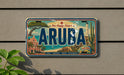 A vintage license plate from Aruba, featuring a colorful illustration of the island's landmarks and scenery.
