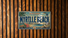A vintage license plate from Myrtle Beach, South Carolina, with a colorful illustration of the beach and surrounding area.
