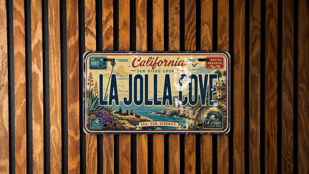 A California license plate with the text "LA Jolla Cove" printed on it, mounted on a wooden wall.