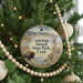 A circular ornament hanging on a Christmas tree, featuring a scenic image of Antelope Island, Utah, with a bison and a deer in the foreground.
