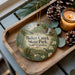 A wooden tray with a decorative ornament featuring a scenic image of Baker Creek State Park, South Carolina, and pine cones.