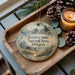 A wooden tray with a decorative ornament featuring a scenic landscape of Bandon State Natural Area, Oregon, and pine cones.