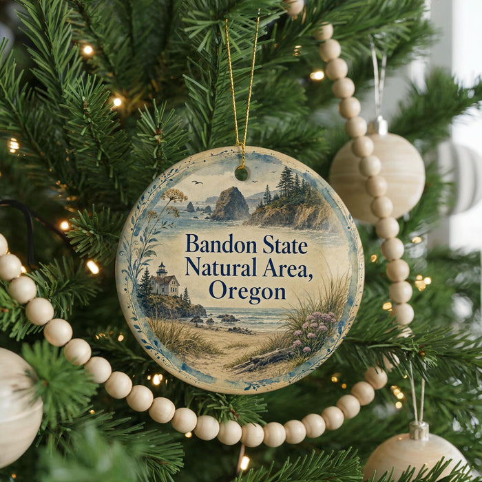 A round ornament hanging on a Christmas tree, featuring a scenic landscape of the Bandon State Natural Area, Oregon.