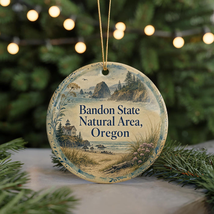 A round ornament with a scenic landscape of Bandon State Natural Area, Oregon, featuring a lighthouse, mountains, and a beach.