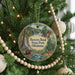 A round ornament hanging on a Christmas tree, featuring a scenic image of Beaver Bend State Park, Oklahoma.
