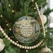 A round ornament hanging on a Christmas tree, featuring a scenic image of Betty and Wilbur Davis State Park in New York.