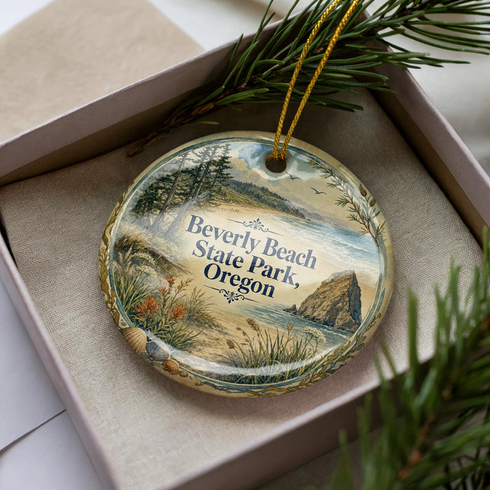 A decorative ornament in a box, featuring a scenic landscape with a beach, mountains, and pine trees.