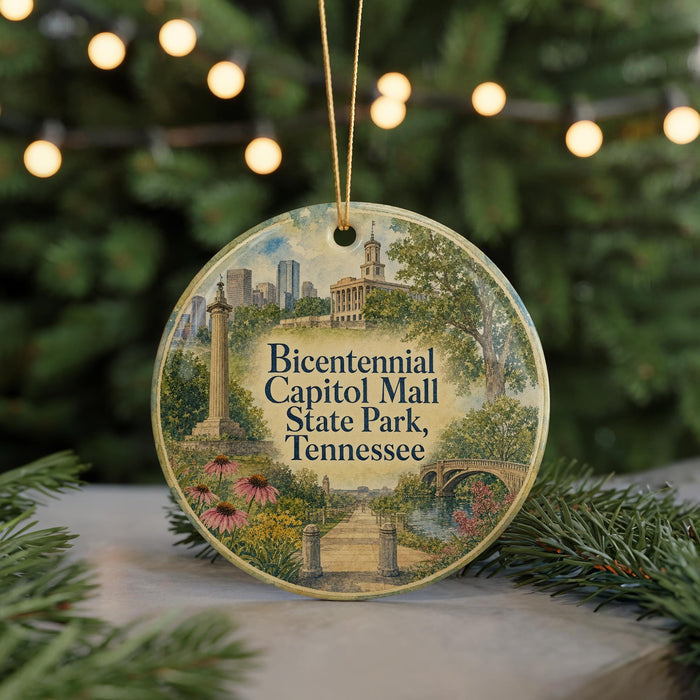 A circular ornament with a painting of the Capitol Mall in Tennessee, surrounded by greenery and a string of lights.