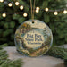 A round ornament with a scenic landscape of Big Bay State Park, Wisconsin, featuring a waterfall, pine trees, and a lake.