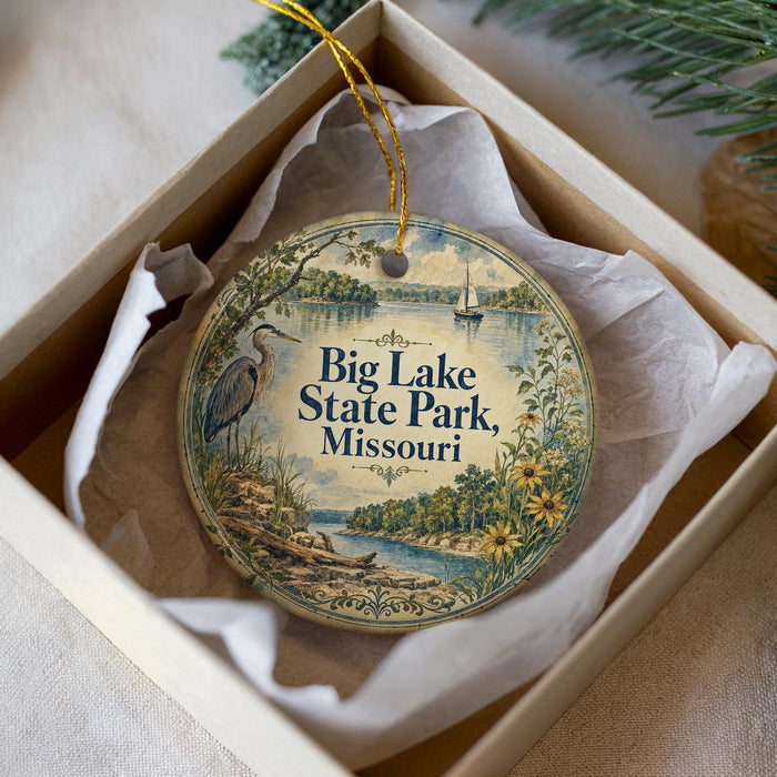 A decorative ornament in a box, featuring a scenic image of Big Lake State Park in Missouri.
