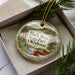 A decorative ornament in a box, featuring a scenic image of Black Mesa State Park, Oklahoma.