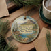 A decorative ornament featuring a scenic landscape of Bluewater Lake State Park, New Mexico, with pine trees and a lake in the background.