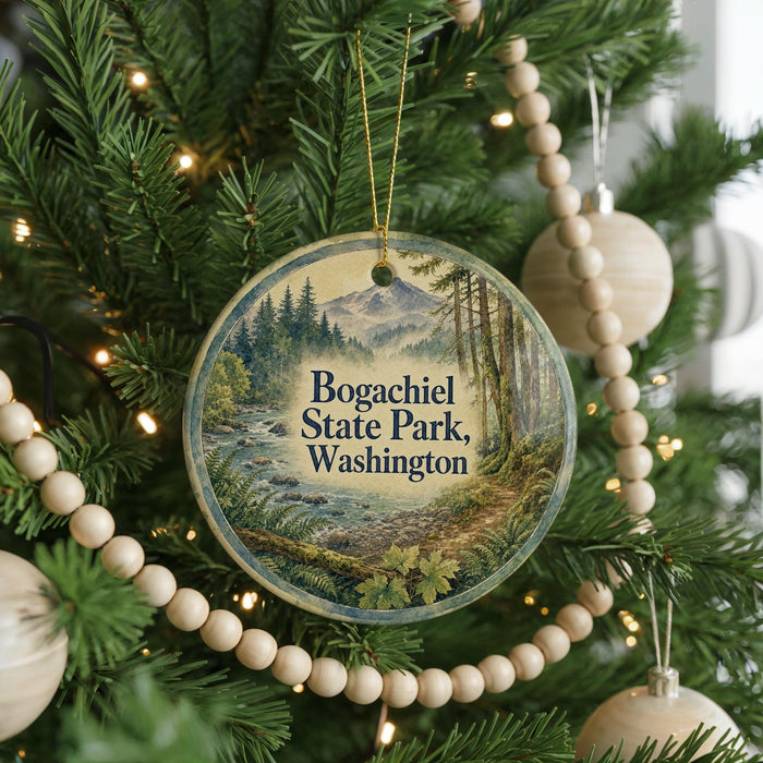 A circular ornament hanging on a Christmas tree, featuring a scenic landscape with a mountain and a river.