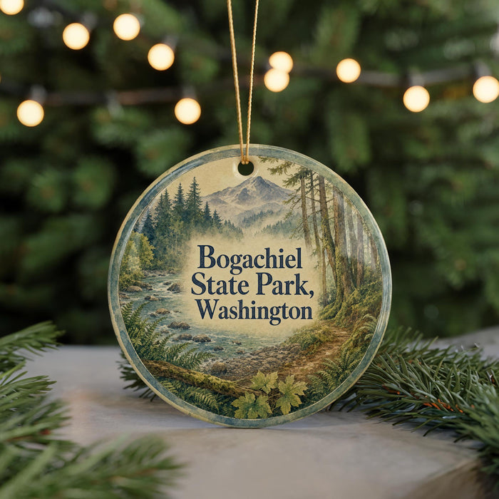 A round ornament with a scenic image of Bogachiel State Park in Washington, surrounded by pine branches and twinkling lights.