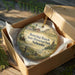 A decorative ornament in a wooden box, featuring a scenic landscape with a barn, windmill, and other rural elements, along with the text "Boring Ranch State Historical Park, Nebraska".