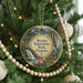 A round ornament hanging on a Christmas tree, featuring a scenic image of Breaks Interstate Park, Virginia.