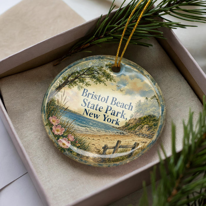 A decorative ornament in a box, featuring a scenic image of Bristol Beach State Park in New York.