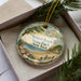 A decorative ornament in a box, featuring a scenic image of Bristol Beach State Park in New York.