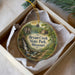 A decorative ornament in a box, featuring a scenic image of a waterfall and a house, with the text "Bryant Creek State Park, Missouri" printed on it.
