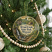 A round ornament hanging on a Christmas tree, featuring a scenic image of a waterfall and a house, with the text "Bryant Creek State Park, Missouri" displayed on it.
