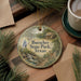 A decorative ornament with the text "Buescher State Park, Texas" is displayed on a wooden surface, surrounded by pine branches and a cup of coffee.