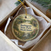 A round ornament in a box, featuring a scenic landscape with a river, bridge, and buildings, with the text "Burlingame State Park, Rhode Island" printed on it.