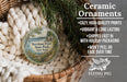 Ceramic ornaments, featuring a design of Burnham Point State Park, New York, hanging in a basket with pine branches.