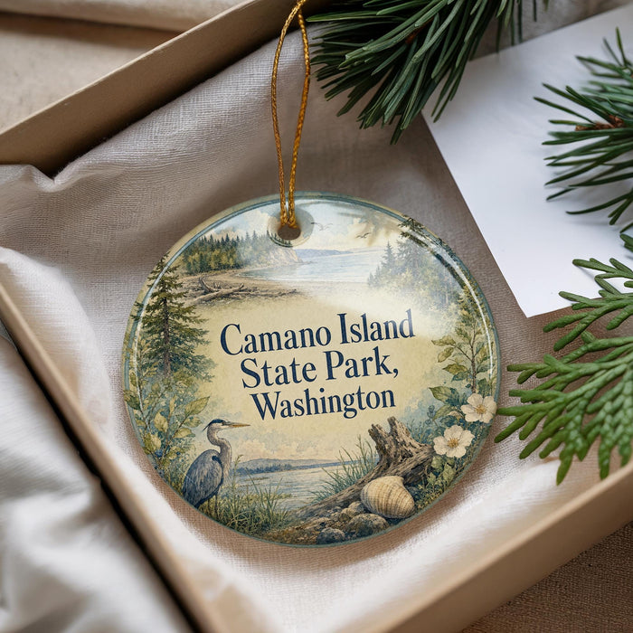 A decorative ornament with a bird and a scenic landscape, hanging from a string.