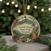 A decorative ornament with a landscape scene featuring mountains, pine trees, and a river, hanging from a string.
