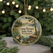 A round ornament with a painting of Camp Wooten State Park in Washington, surrounded by pine branches and greenery.
