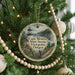 A round ornament hanging on a Christmas tree, featuring a lighthouse and a scenic view of Cape Meares State Scenic Viewpoint, Oregon.