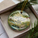 A decorative ornament with a scenic landscape of a river, trees, and flowers, featuring the text "Capital Springs State Recreation Area, Wisconsin".