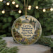 A round ornament with a scenic landscape featuring a cabin, waterfall, and mountains, hanging from a string.