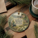 A decorative ornament featuring a scenic image of the Carnifix Ferry Battlefield State Park in West Virginia, with a small cabin and bridge in the background.